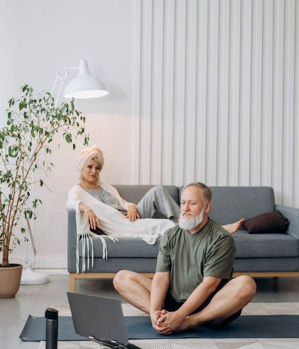 Person in a calm yoga pose in a minimalist dark room.